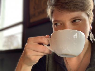person with cup of tea in front of their face